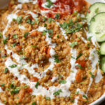 mung bean kitchari in a bowl with non-dairy yogurt on top and cucumbers on the side