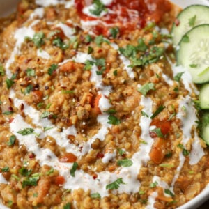 mung bean kitchari in a bowl with non-dairy yogurt on top and cucumbers on the side