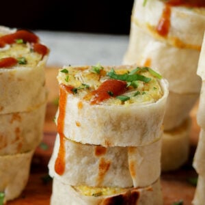 close-up of sliced samosa pinwheels on the cutting board drizzled with tamarind chutney