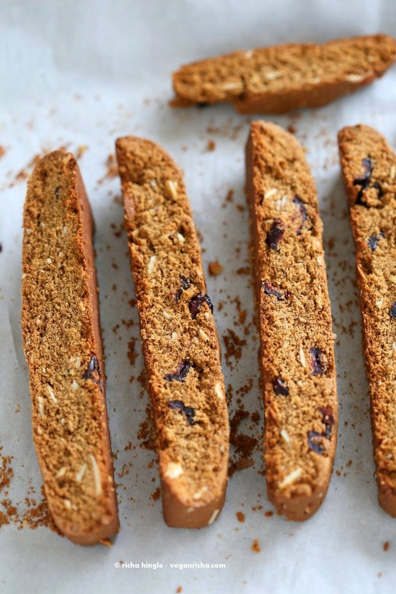 Vegan Gingerbread Biscotti with cranberries, almonds, candied ginger. Easy Crispy Spiced Biscotti Recipe to dunk in a cup of tea. Drizzle with white or dark chocolate. | VeganRicha.com #vegan #gingerbread #biscotti #recipe