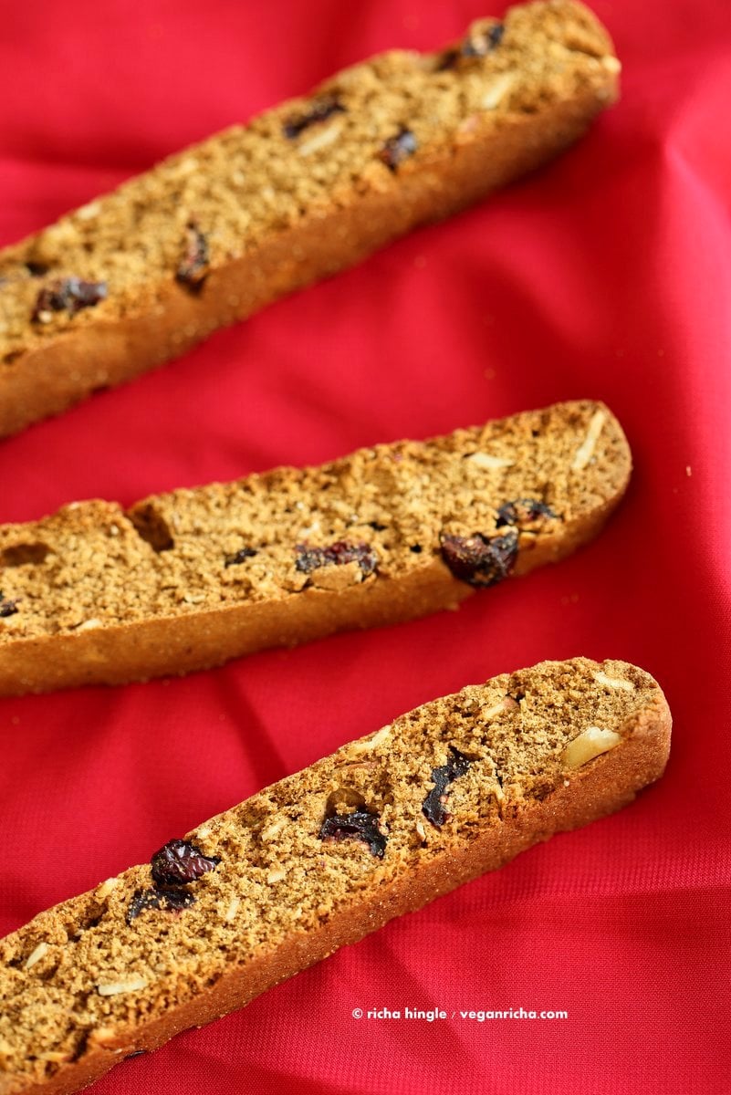 Vegan Gingerbread Biscotti with cranberries, almonds, candied ginger. Easy Crispy Spiced Biscotti Recipe to dunk in a cup of tea. Drizzle with white or dark chocolate. | VeganRicha.com #vegan #gingerbread #biscotti #recipe