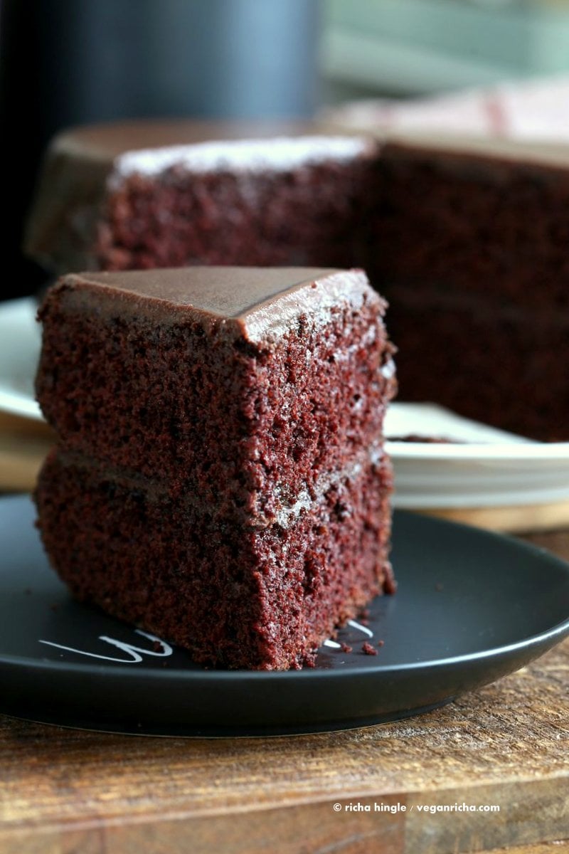 Vegan Chocolate Cake with Chocolate Peanut Butter Ganache on a black plate kept on a Wood table