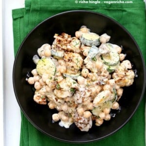 Vegan potato salad in a black bowl on a green kitchen towel