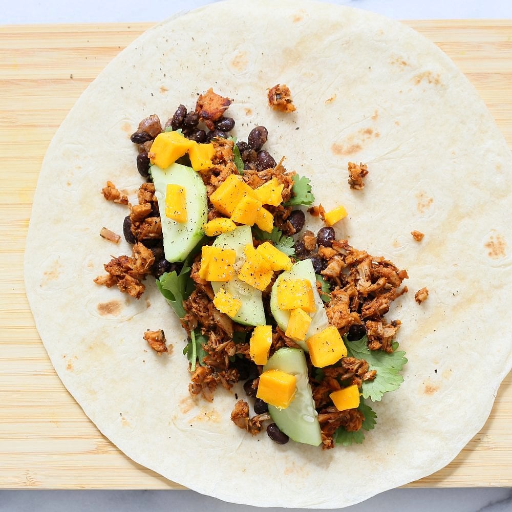 Jamaican Jerk Jackfruit Caribbean Black Bean Mango Wraps. These Burritos are packed with hot shredded jerk jackfruit, black beans, mango and cucumbers. Serve as wraps or make a sandwich or bowl. Vegan Soy-free Recipe. Can be gluten-free | VeganRicha.com