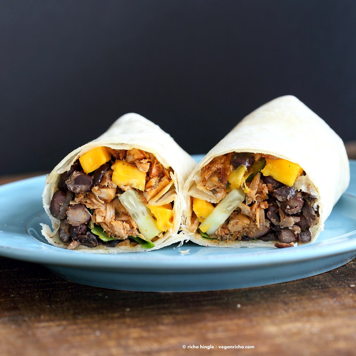Jamaican Jerk Jackfruit Caribbean Black Bean Mango Wraps. These Burritos are packed with hot shredded jerk jackfruit, black beans, mango and cucumbers. Serve as wraps or make a sandwich or bowl. Vegan Soy-free Recipe. Can be gluten-free | VeganRicha.com
