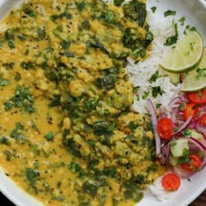 red lentil dal with spinach in a bowl with rice and veggies