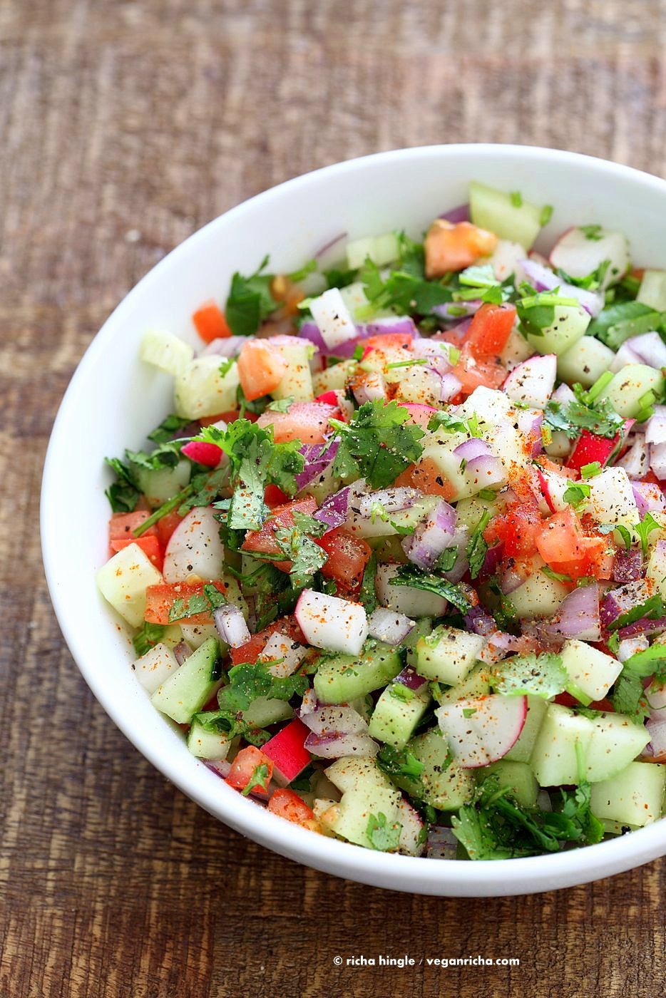 Chopped Kachumbar Salad with cucumber, radish, onion, tomato in a White Bowl