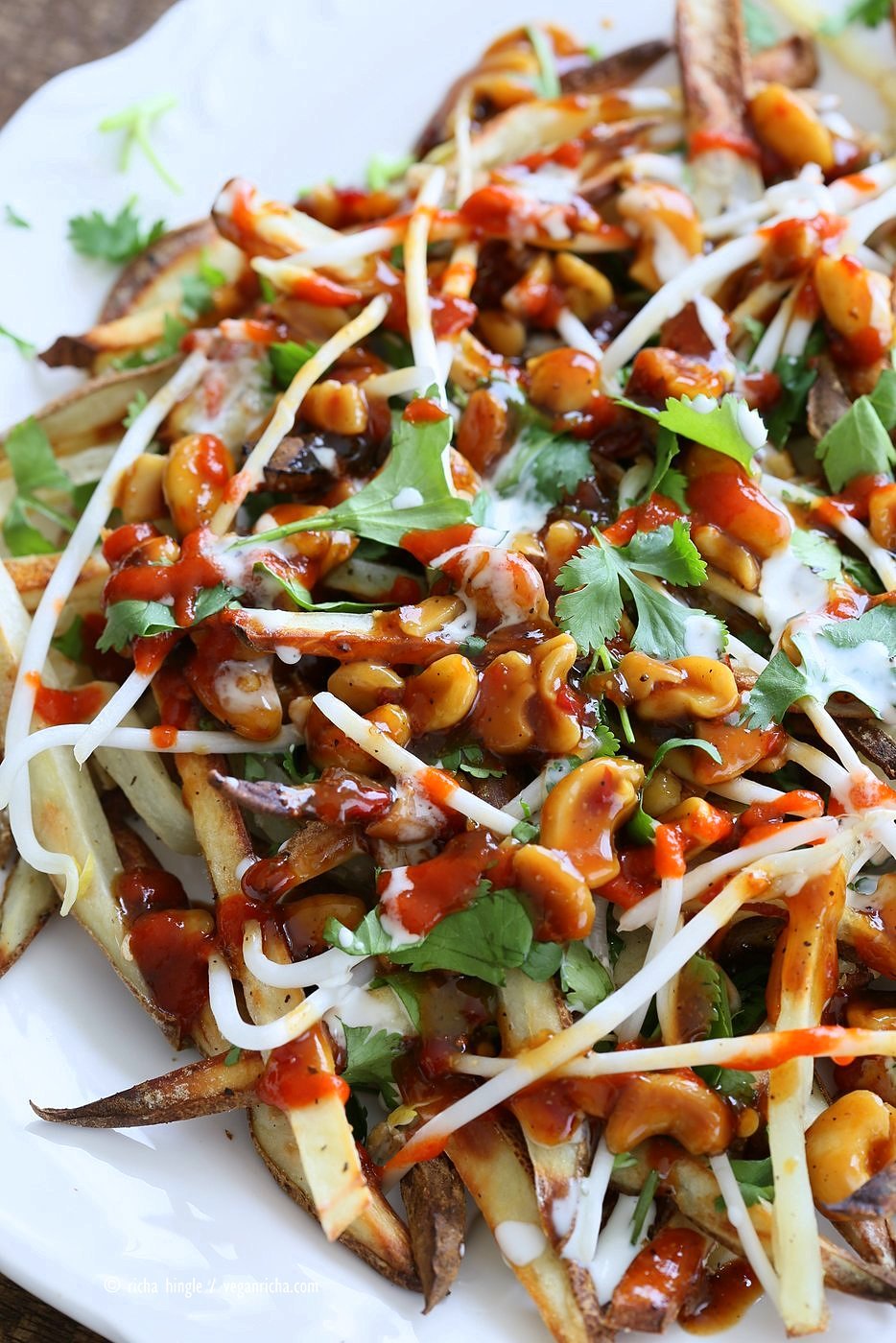 Baked Vietnamese fries. Baked Potato strips, loads of cilantro and basil, bean sprouts, nuts in sweet chile sauce, sriracha and vegan mayo! Banh mi Sandwich in fries form. Vegan Gluten-free Recipe. | VeganRicha.com