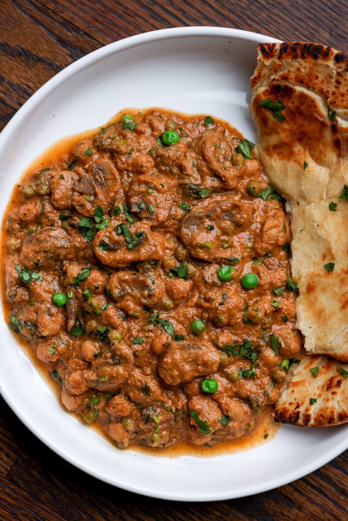 bowl of mushroom matar masala with flatbread
