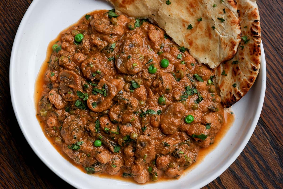 bowl of mushroom matar masala with flatbread
