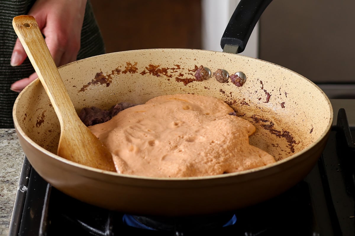 adding tomato mixture to the pan