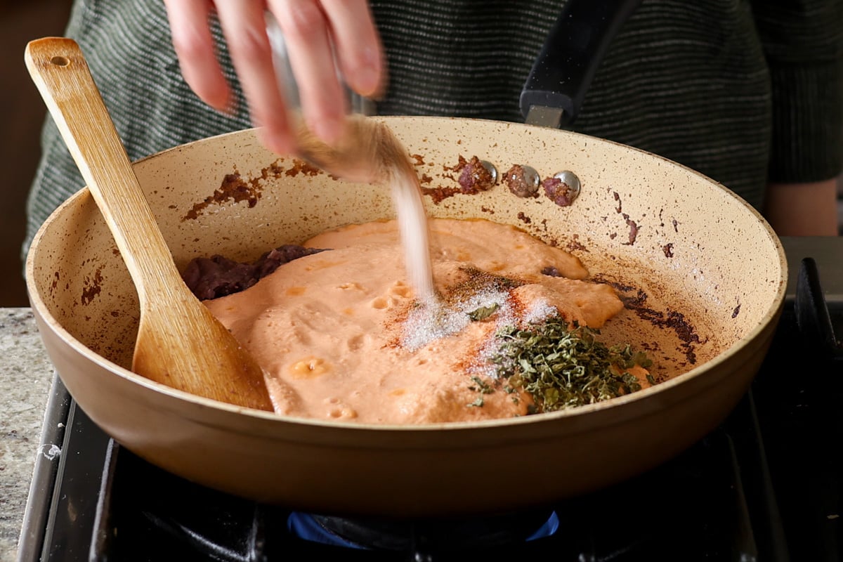 adding sugar, salt, and spices to the pan