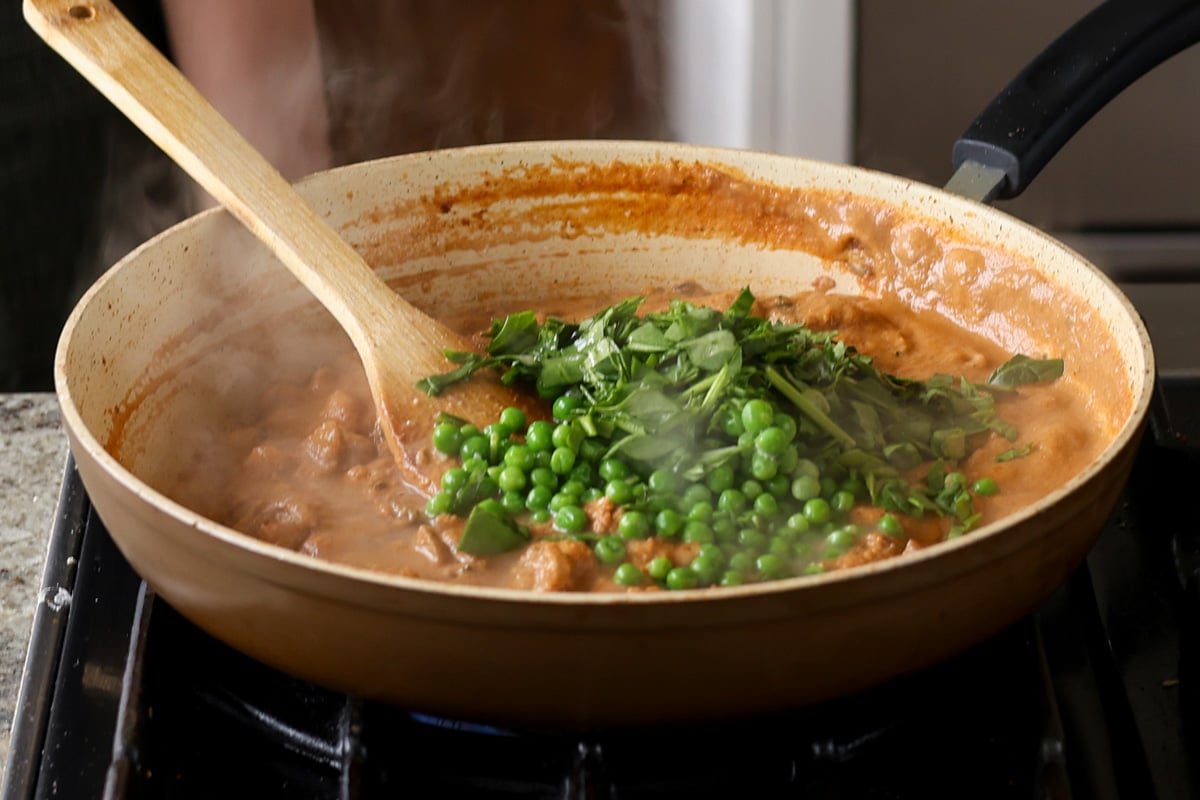 adding peas and spinach to the matar masala