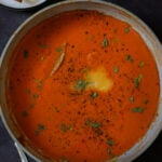 spiced tomato soup in the pan with garnishes