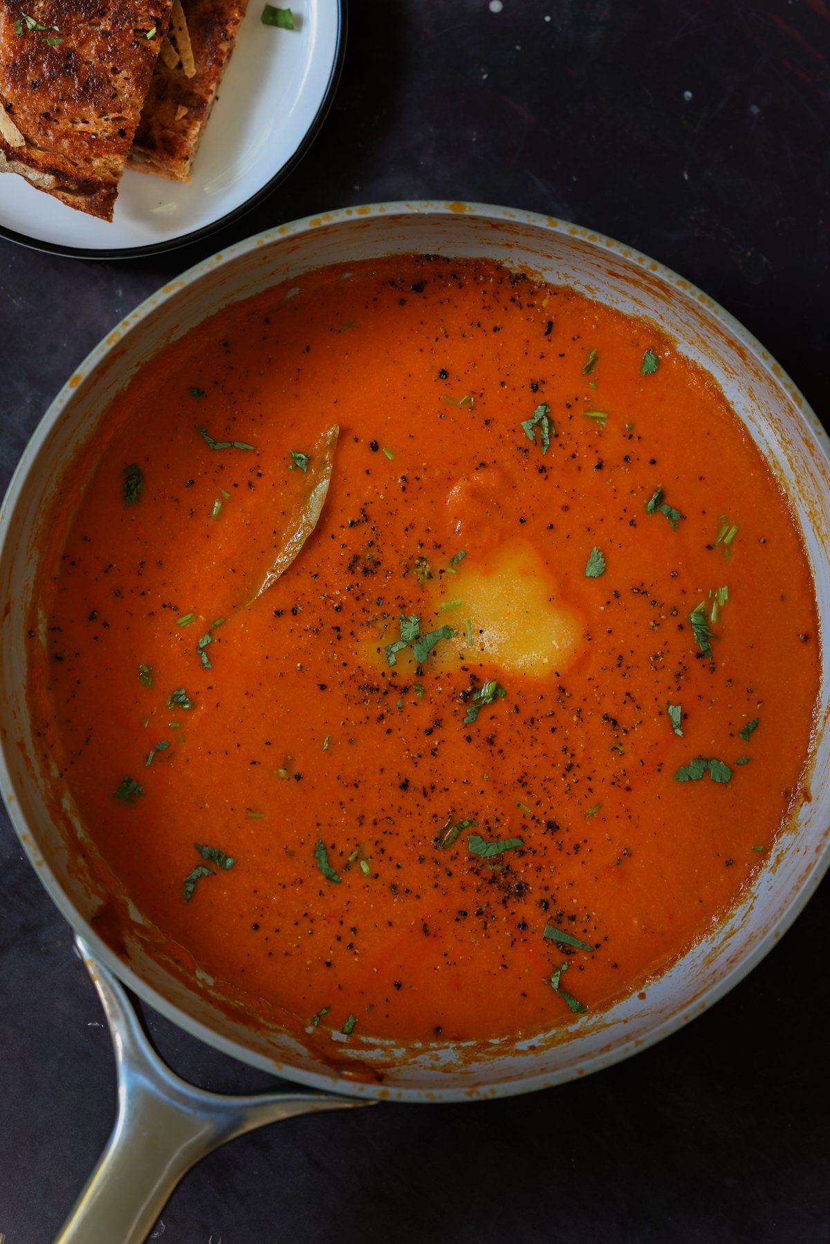 spiced tomato soup in the pan with garnishes