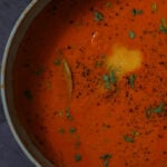 close-up of spiced tomato soup in the pan with garnishes