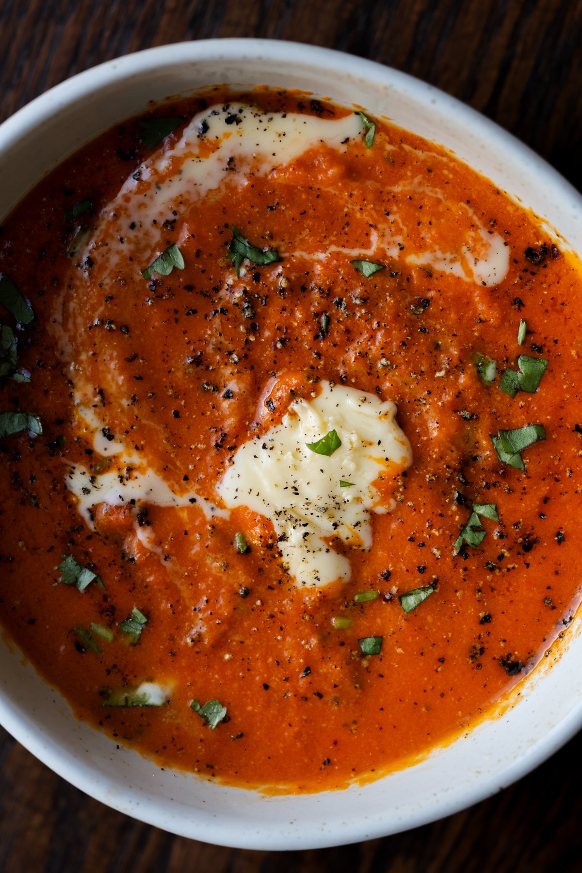close-up of bowl of spiced tomato soup with garnishes