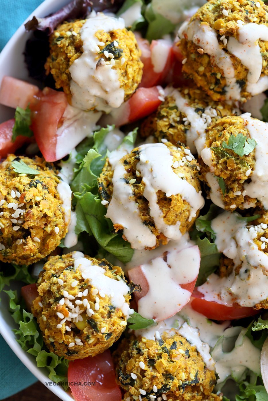 Turmeric Lentil Fritters Tomato Greens Bowl with Tahini Dill Sauce. Baked Seedy Golden Lentil fritters with greens, tomatoes and a tahini sauce make an easy Lunch bowl. #Vegan #Nutfree #Soyfree #Recipe. Easily #Glutenfree #veganricha | VeganRicha.com