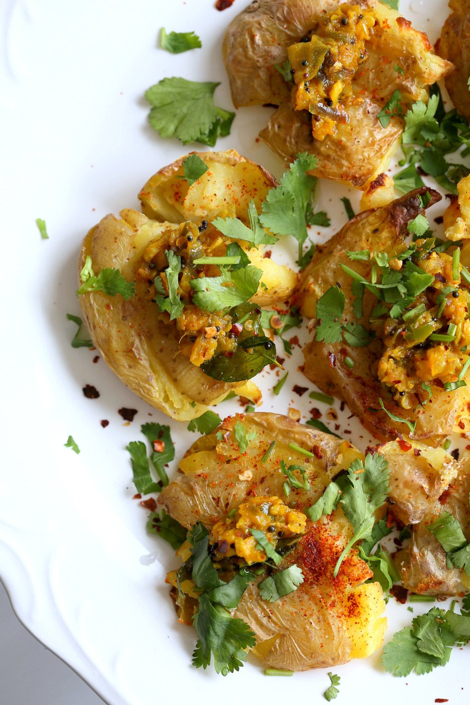 Indian Spiced Smashed Potatoes with Mustard Ginger Tempering. Bonda like Samosa is a spiced potato snack. These smashed potatoes are topped with Bonda style tempering of ginger, chile, turmeric and mustard seeds. Vegan Gluten-free Recipe | VeganRicha.com