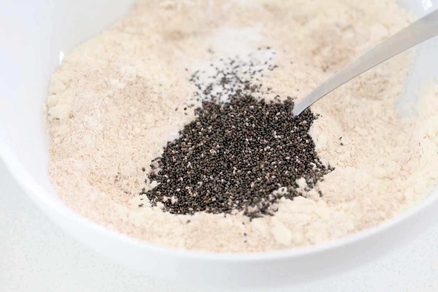 Dry ingredients mixed in a white bowl for Our Vegan Turmeric Carrot Muffins