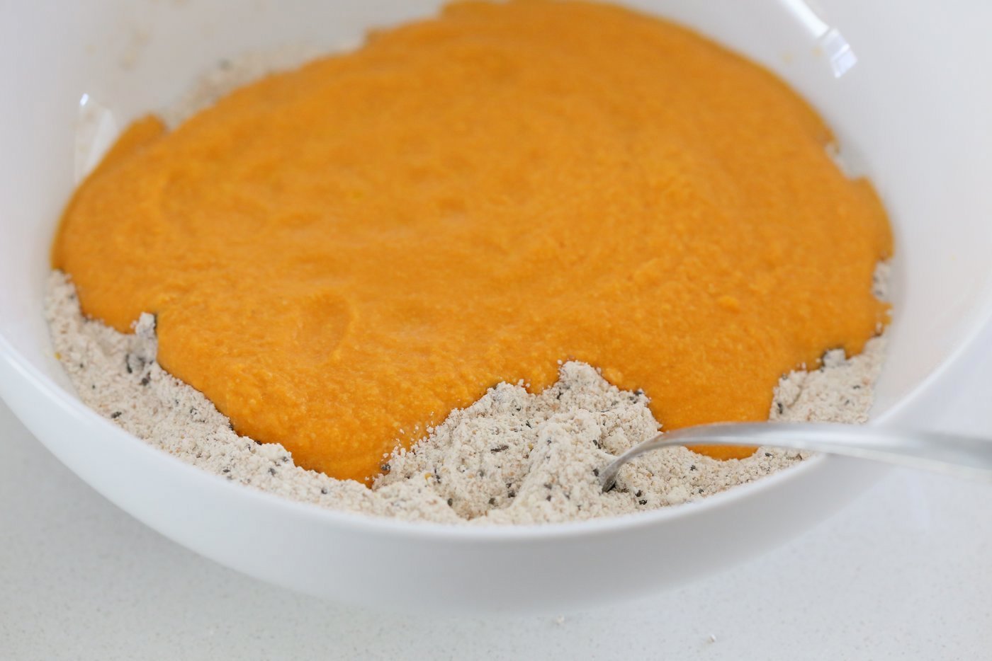 Add blended wet ingredients to the dry for Our Vegan Turmeric Carrot Muffins