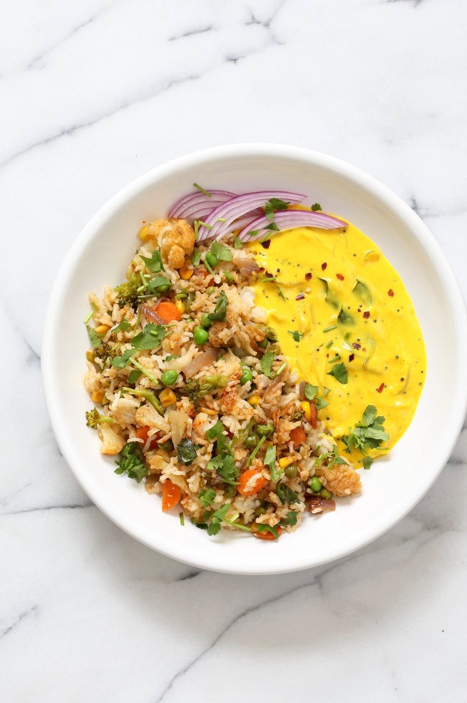 Indian Spiced Masala Veggie Fried Rice with Turmeric Onion Raita. Use up the leftover rice or grains to make this quick spiced fried rice and serve with a simple yogurt raita that is spiced with turmeric and mustard seeds. Vegan Gluten-free Soy-free Indian Recipe | VeganRicha.com