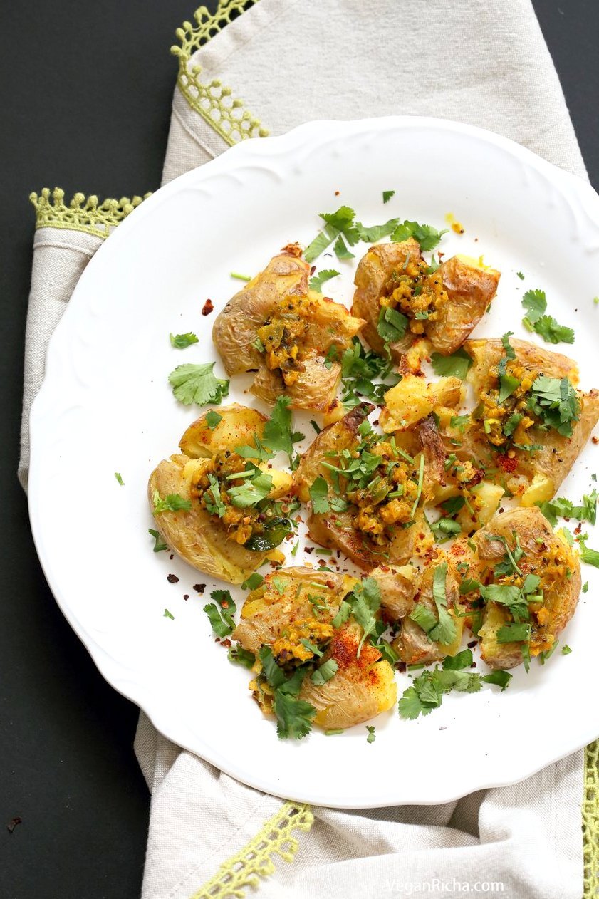 Indian Spiced Smashed Potatoes with Mustard Ginger Tempering. Bonda like Samosa is a spiced potato snack. These smashed potatoes are topped with Bonda style tempering of ginger, chile, turmeric and mustard seeds. Love Indian Snacks Like Samosa or Bonda? Then you will love these. All the flavor, half the work! #Vegan #Glutenfree #veganricha #nutfree #soyfree #Recipe | VeganRicha.com