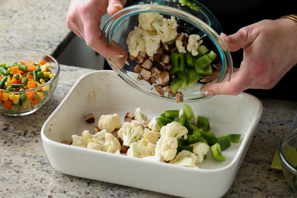 adding fresh veggies to the casserole dish