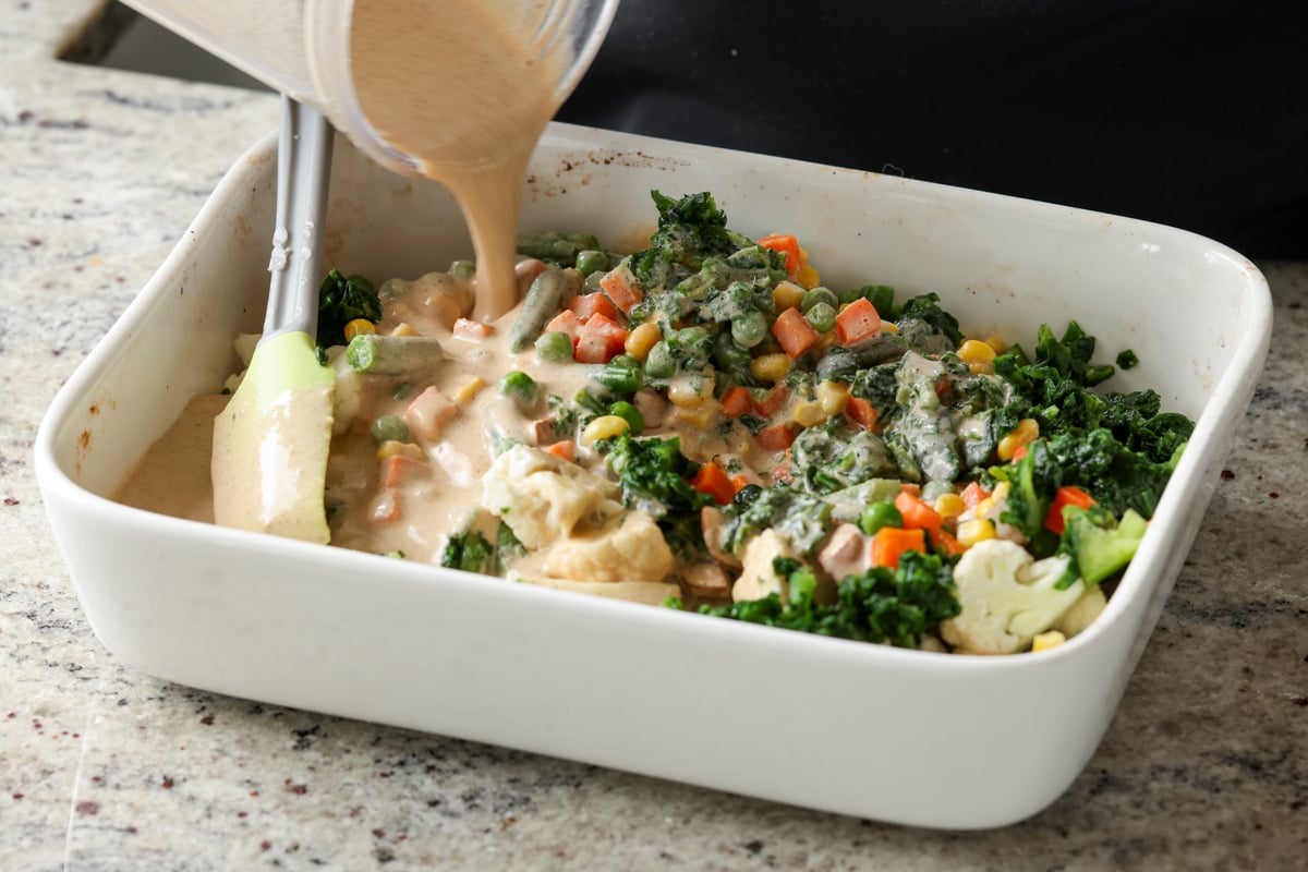 adding blender masala sauce to the casserole dish
