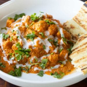 close-up of butter tofu paneer in a bowl with naan