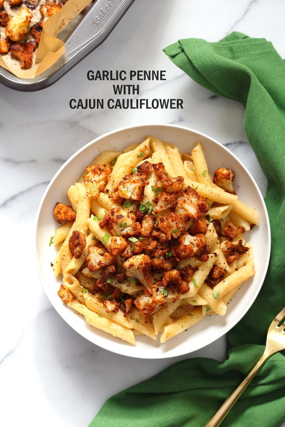 Creamy Garlic Penne with Cajun Cauliflower in a shallow Bowl with Green Napkin