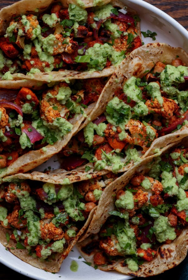 cauliflower sweet potato tacos on a plate with coconut chutney and garnishes