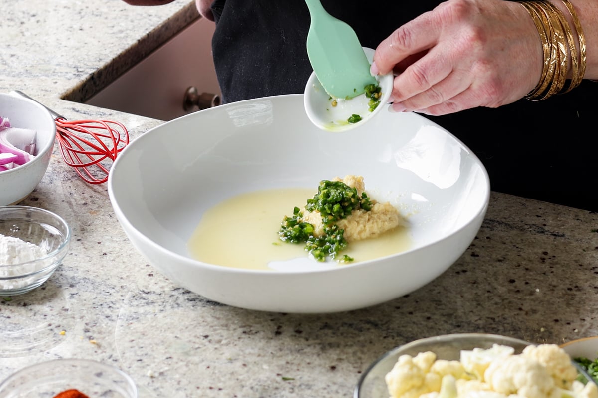 adding tikka masala marinade ingredients to a bowl