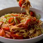 fork taking a bite from a bowl of Hakka noodles