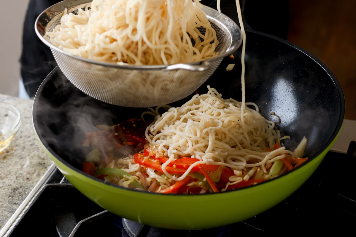 adding the cooked Hakka noodles to the cooked veggies