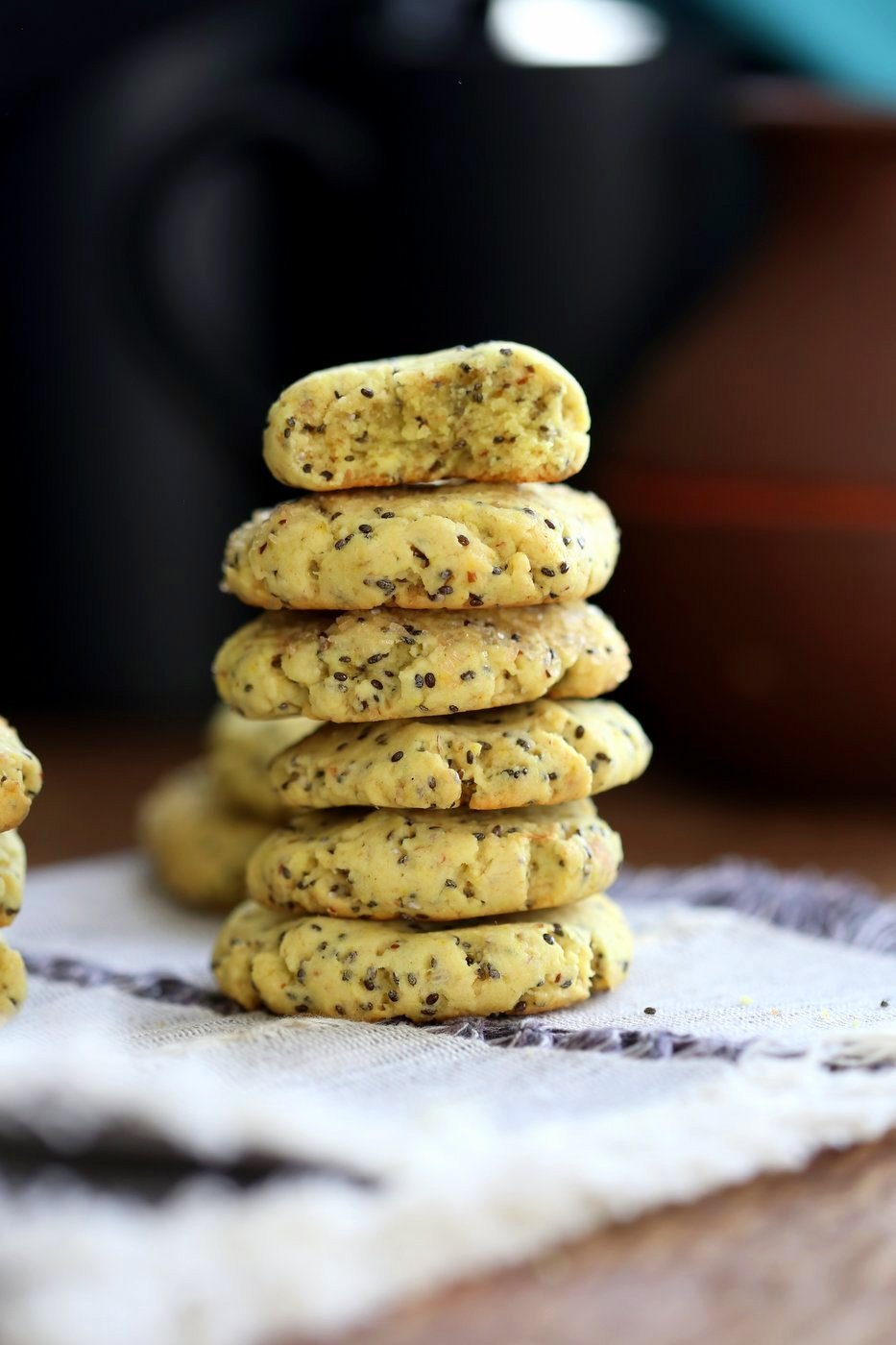 Vegan Lemon Cookies stacked on grey napkin over wood table