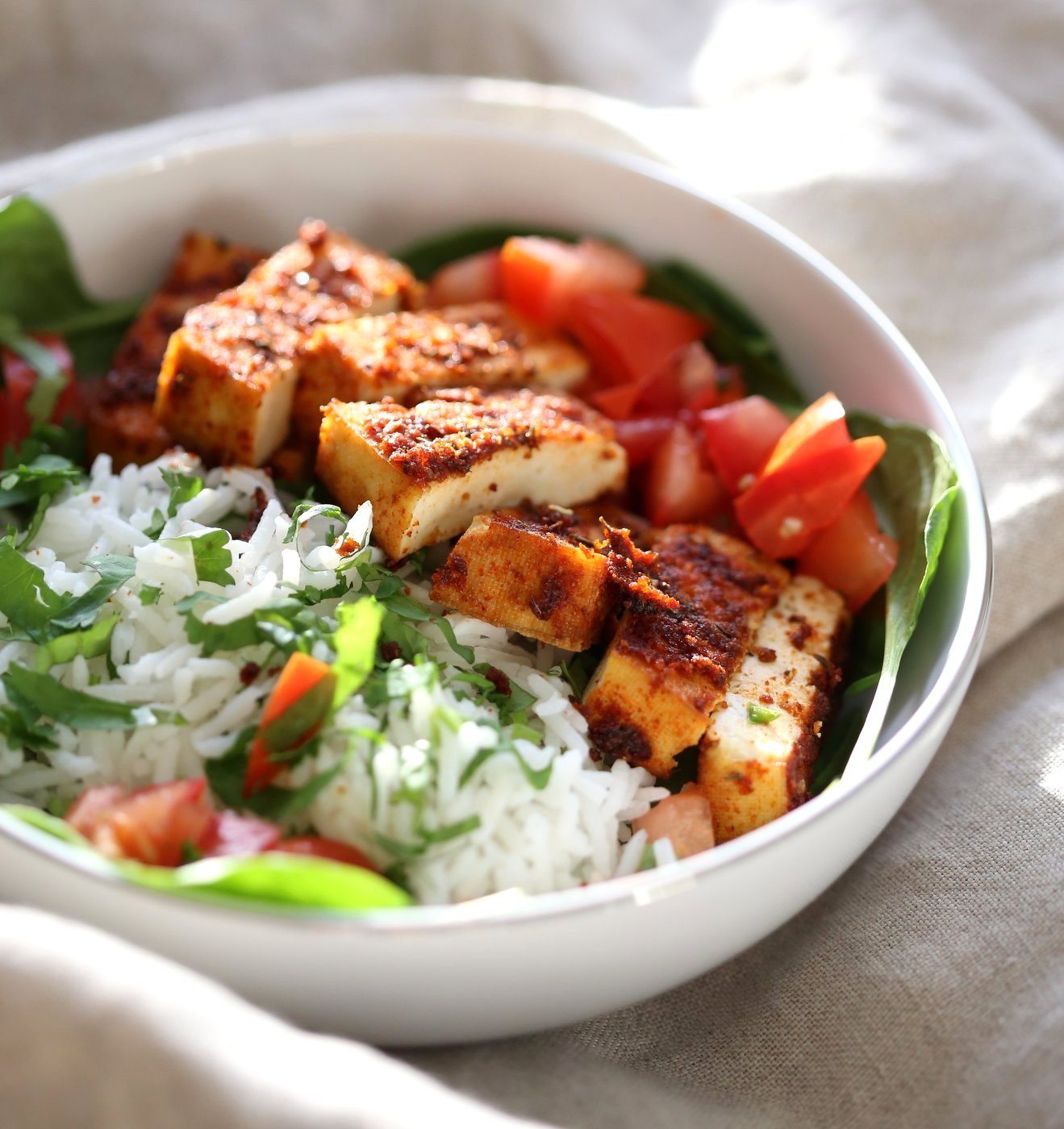 Cajun Tofu with Cilantro Lime Rice. Baked Cajun Spiced Tofu, over greens, cilantro lime rice, and tomatoes. Easy Spicy Bowl. Vegan Gluten-free Nut-free Recipe. Use Chickpea tofu to make soy-free. | VeganRicha.com
