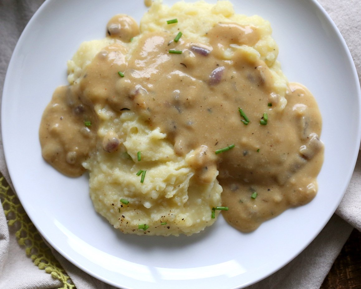 Simple Vegan Gravy over mashed potatoes in white plate