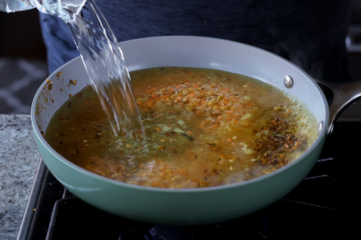 adding water to the lentils and rice