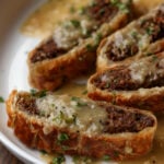 angled shot of lentil wellington on a plate with gravy to show more texture