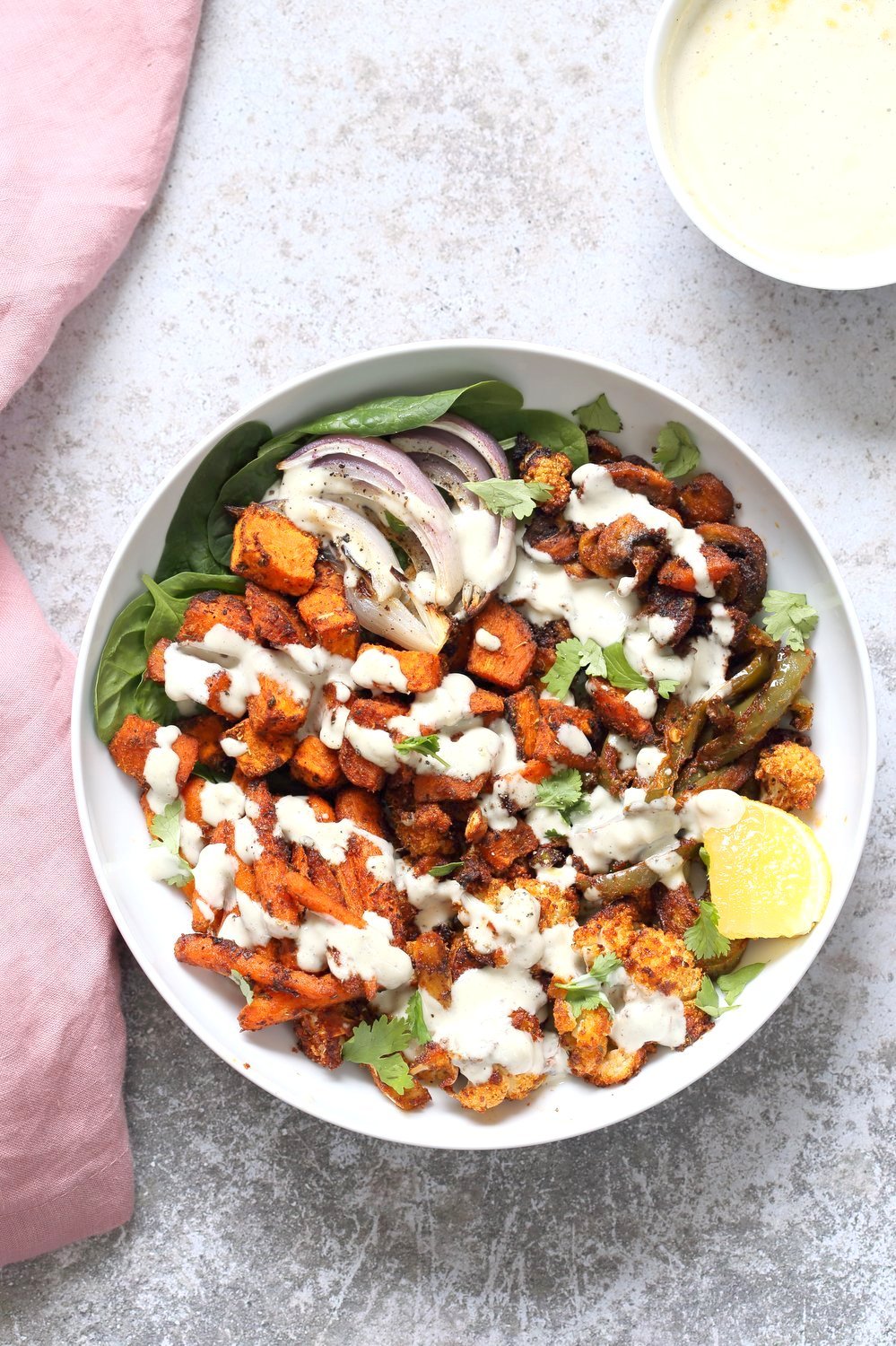 Cajun Roasted Vegetable Bowl with Garlic Sauce. Mushrooms, Cauliflower, Sweet Potato, Peppers, Onions, tossed in cajun spice blend and roasted. Serve in a bowl with crunchy greens and creamy garlic sauce or make wraps or tacos. #veganricha #Vegan #Glutenfree #Soyfree #Recipe. Can be nut-free. | VeganRicha.com