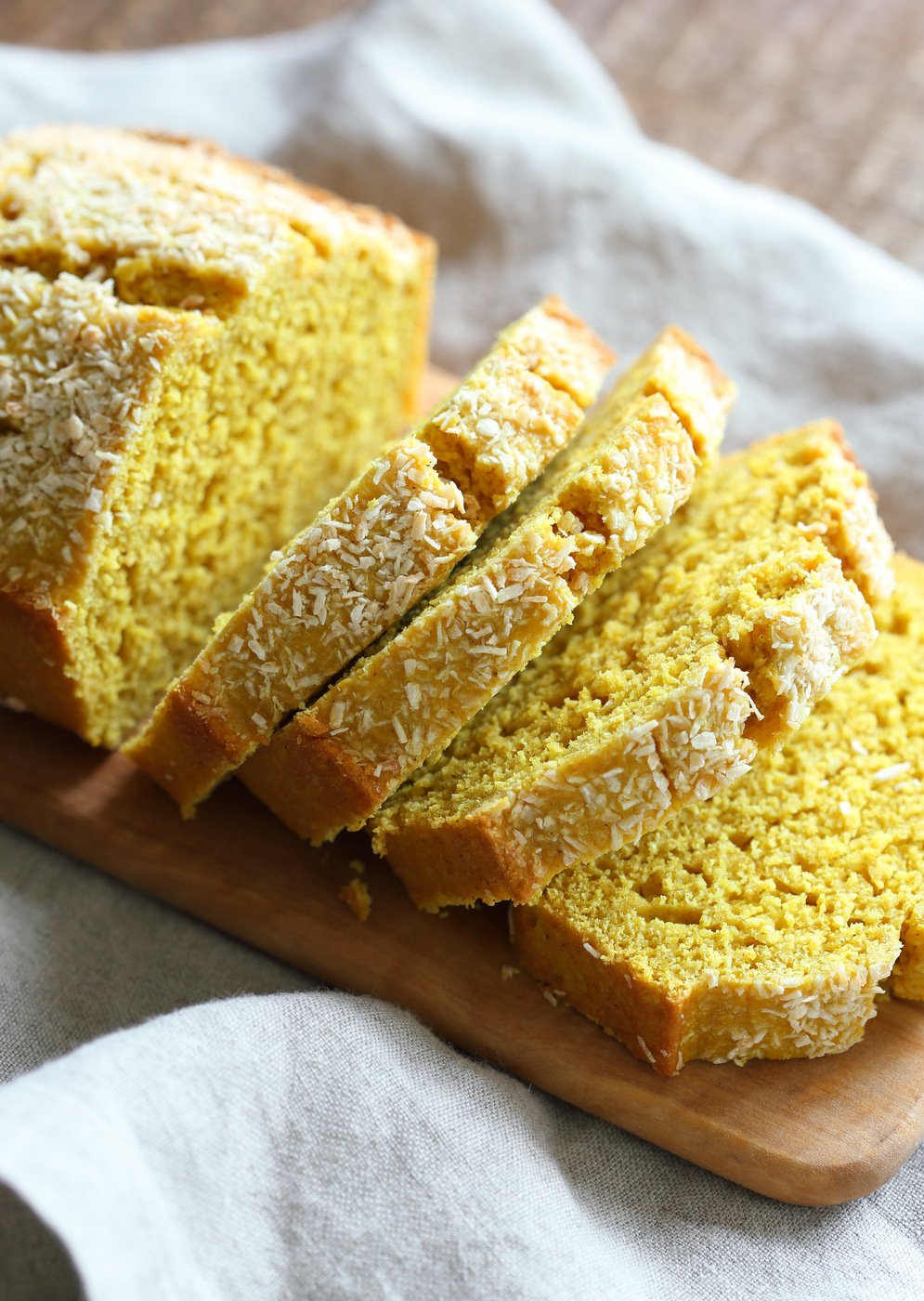 Golden Coconut Turmeric Bread on wood paddle kept over grey cotton napkin