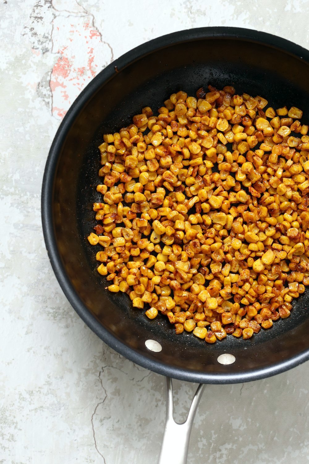 Roasted Corn for our Mexican Street Corn Sala, in a Black Skillet kept over concrete