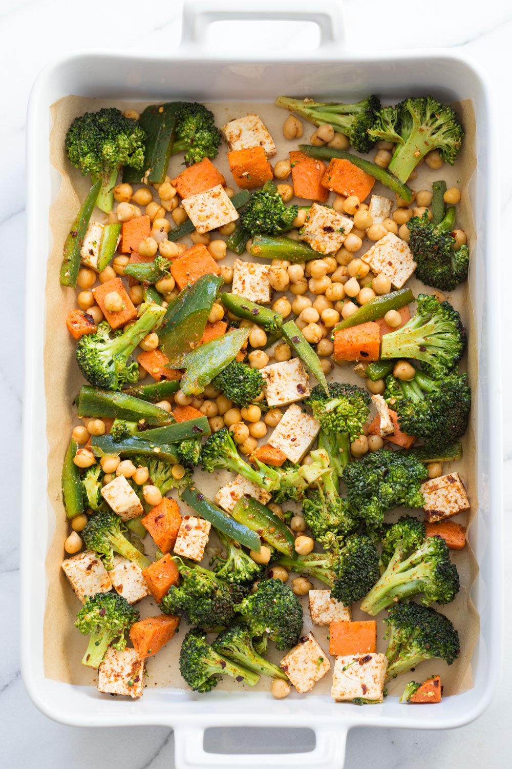 Spiced Veggies, Chickpeas, Tofu, Broccoli, Sweet Potato in parchment lined Baking dish, read to be baked