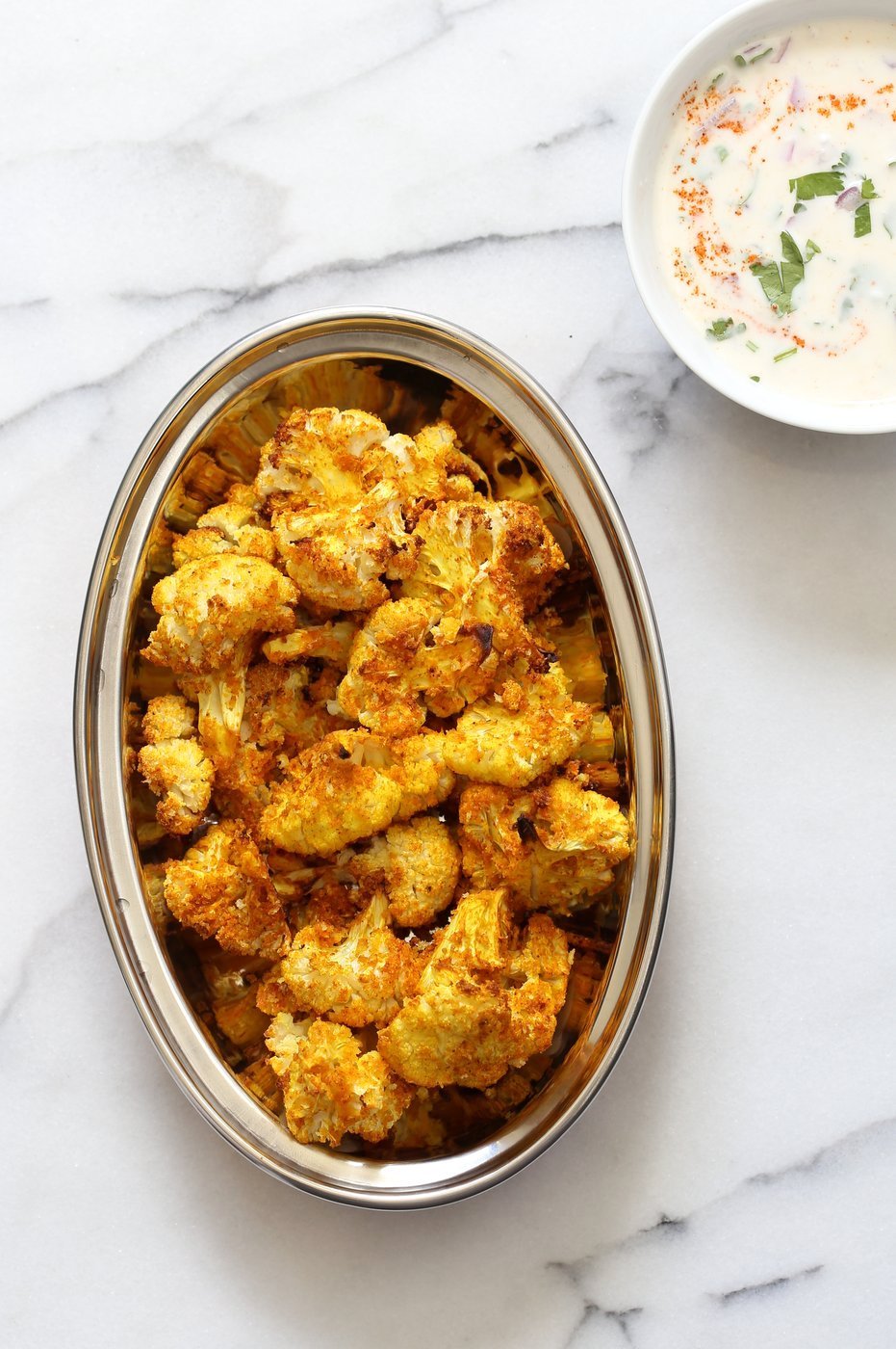 Turmeric Roasted Cauliflower with Raita Dip. These Delicious Golden Cauliflower Bites are easy and quick. Serve with a dash of lemon or with a Yogurt onion dip or Green Chutney. #Vegan #Soyfree #Nutfree #veganricha #Recipe. Can be #glutenfree