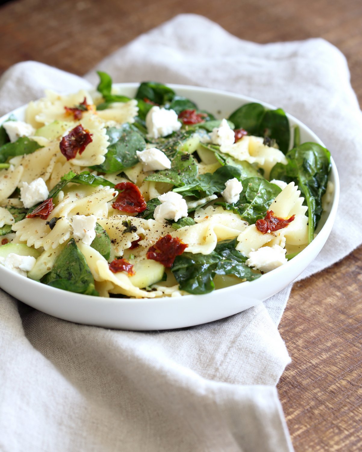 Tuscan Pasta Salad with Lemon Garlic Herb Vinaigrette. Farfalle Pasta Salad with sun dried tomato, cucumber, spinach, vegan feta and Tuscan/Mediterranean flavors. #Vegan #Soyfree #Recipe. Can be #nutfree and #glutenfree #veganricha