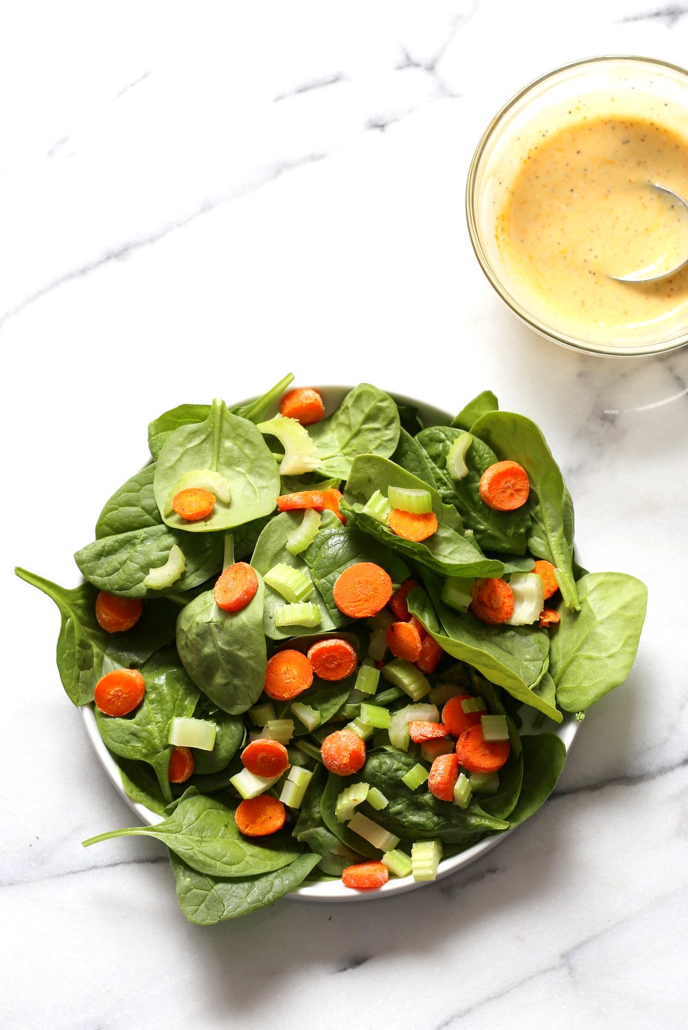 Sriracha Chickpeas Spinach Bowl getting assembled on marble