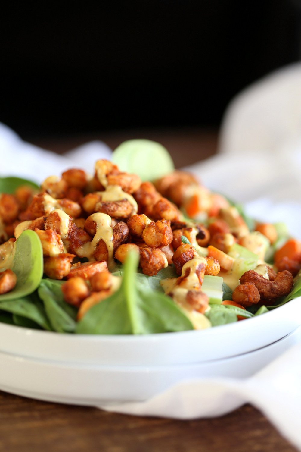 Sriracha Chickpeas Spinach Bowl with Ranch dressing kept on marble