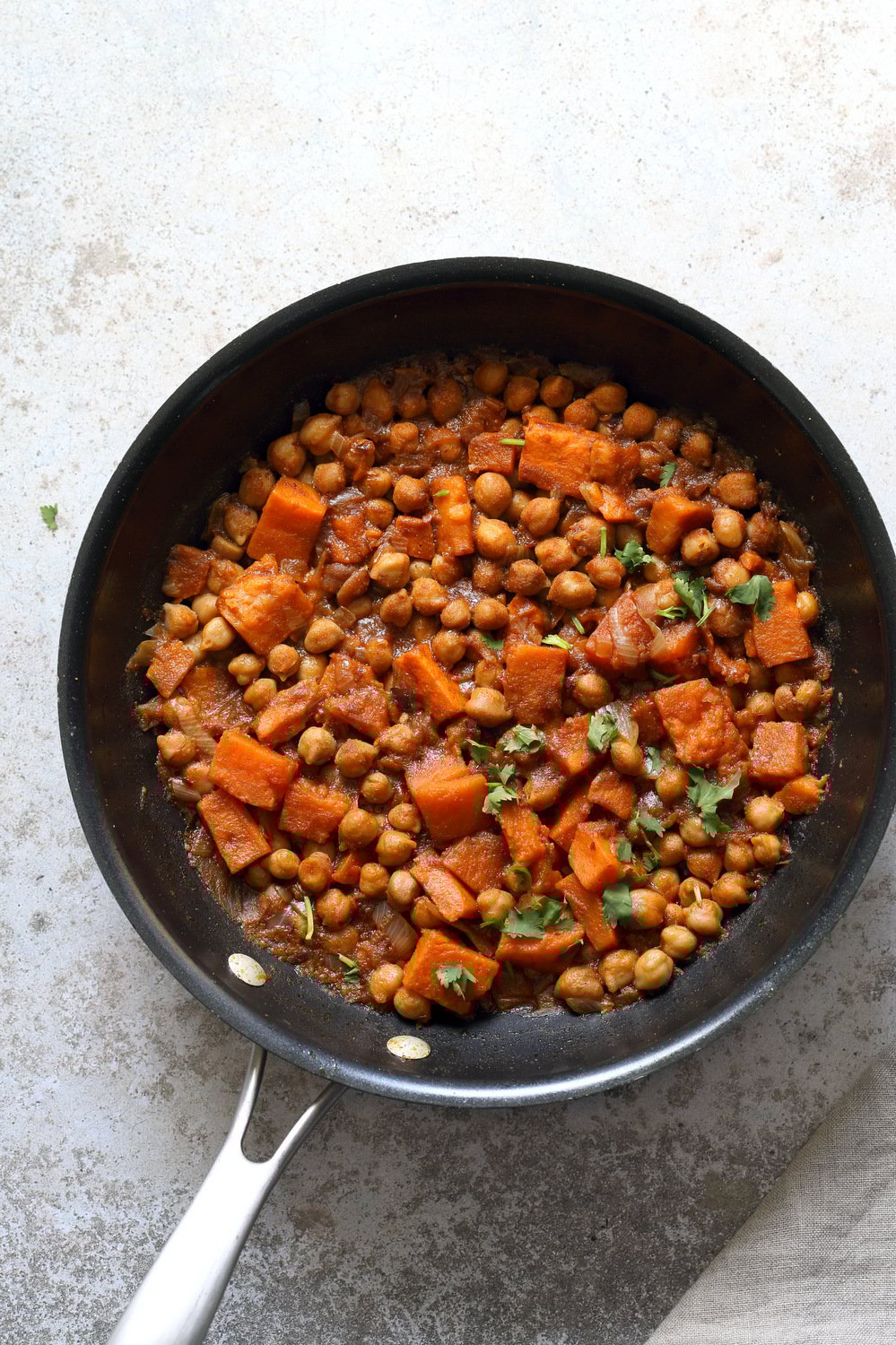 Our Harrisa Chickpea Stew in Black Skillet over Concrete