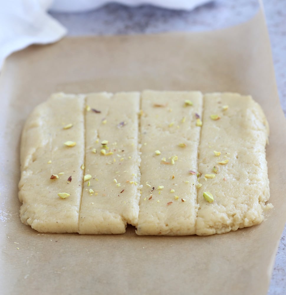 Making our Vegan Malai Burfi- Shaped Burfi mixture on Parchment is sliced to bake